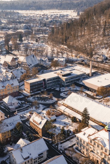 Bird's eye view of school buildings and houses in snowy winter landscape with hills, Nagold, Calw district, Black Forest, Germany