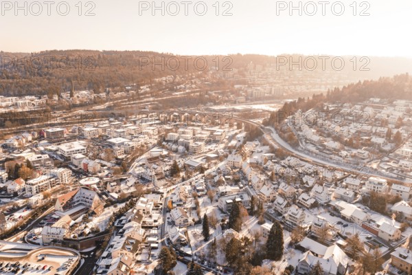 Snowy town on hills under low sunlight, Nagold, Calw district, Black Forest, Germany