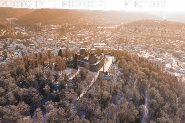 A castle on a hill surrounded by snowy trees, with a view of the city in the morning light, Nagold, Calw district, Black Forest, Germany