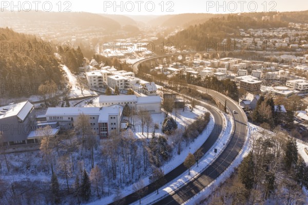 Snowy city landscape with a bridge and roads surrounded by hills and trees, Nagold, Calw district, Black Forest, Germany