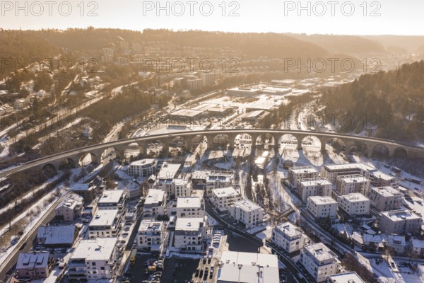 A viaduct over a snowy town with houses, nestled in a hilly landscape, Nagold, Calw district, Black Forest, Germany