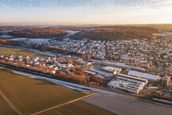 Aerial view of a settlement in winter surrounded by fields and roads, under blue sky, Althengstett, Calw district, Germany