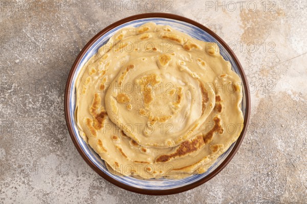 Stack of Plain Fried pancakes on brown concrete background. top view, flat lay, close up