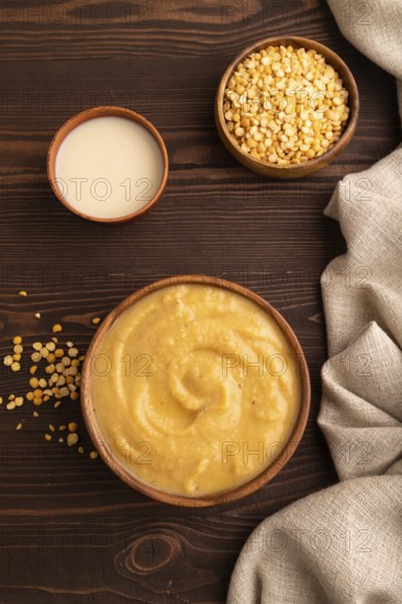 Pea cream soup, Puree, porridge in wooden bowl on wooden background and linen textile. Diet, healthy eating concept. top view, flat lay, close up, minimalism