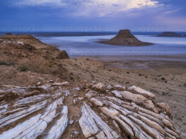 A tourist admires the inselbergs Karamaya and the Three Brothers (Three Batyrs), the Karagiye Depression with its salt lake (Kendirli Sor) on the ancient Tethys Ocean floor, Karyn Zharyk, Ustyurt Reserve, Mangystau, Kazakhstan, Asia