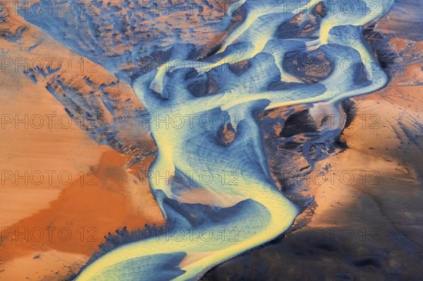 Aerial view of the colorful Þjórsá River, Iceland's longest river, weaving through volcanic landscapes in the Southern Highlands, Iceland