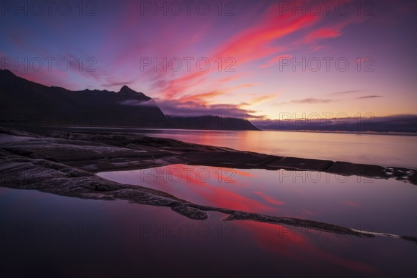 Coastal view in Senja, Norwegian Sea, rugged cliffs and mountains composed mainly of Precambrian gneiss and granite, Norway