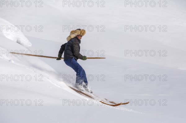 Skier with long traditional wooden skis and a long pole in the Altai Mountains, possibly the birthplace of skiing, Altai Prefecture, Xinjiang Uygur Autonomous Region, Northwest China, Asia