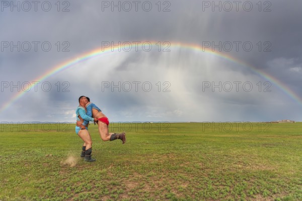 Traditional Mongolian wrestling in summer under a rainbow, Mongolia, Asia