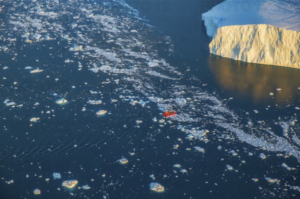 Aerial view of a tourist ship navigating through the fjord among icebergs calved from the Jakobshavn Isbræ (Sermeq Kujalleq) glacier in Disko Bay, the Ilulissat Icefjord, a UNESCO World Heritage Site, Ilulissat, West Greenland (Kalaallit Nunaat), geographically North America, politically part of the Kingdom of Denmark