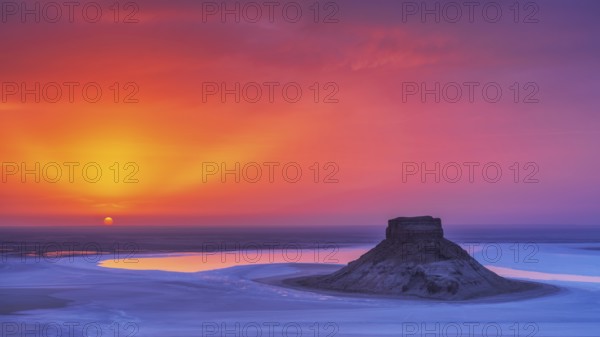Sunset at Karynzharyk Depression with Mount Karamaya rising above the salt plain, unique saline landscape in the Ustyurt Nature Reserve, Mangystau Region, Kazakhstan, Asia
