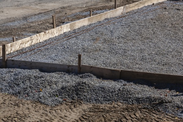 Wooden concrete pouring forms and bed of crushed and compacted stone aggregate to rest concrete slab floor of a building on at construction site, Quebec, Canada