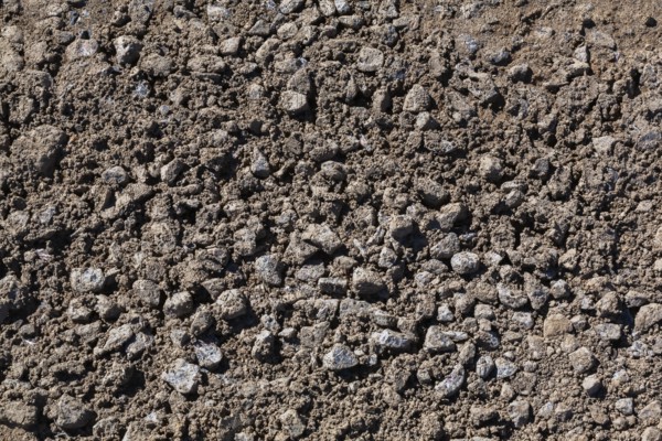 Close-up of sand mixed with grey crushed stone aggregate used to form a bed for constructing roads and driveways on, Quebec, Canada
