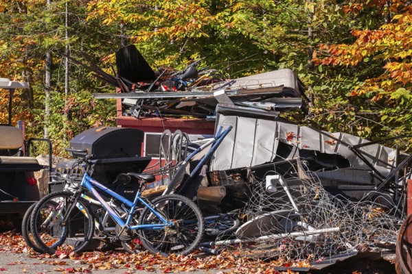 Pile of discarded metal objects including bicycles, sheet metal cladding, pipes, steel wire waiting for transport to recycling yard, Quebec, Canada