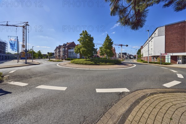 Roundabout, sidewalk, lantern, general architecture, commercial building, residential building, crane, advertising flags on flagpoles, roads, meadow, branch, trees, blue sky, cirrus clouds, roundabout between Butenwall, Im Piepershagen and Burloer Straße, Borken, Münsterland, Borken district, North Rhine-Westphalia, Germany