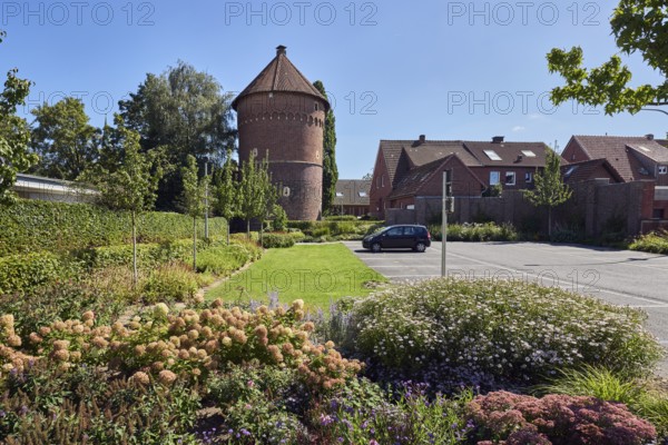 Thief tower, historic brick building, registry office, historic city prison, prison, residential building, houses, park, flower bed, trees, lawn, parking lot with car, side light, blue sky, cloudless, Im Piepershagen, Borken, Münsterland, Borken district, North Rhine-Westphalia, Germany