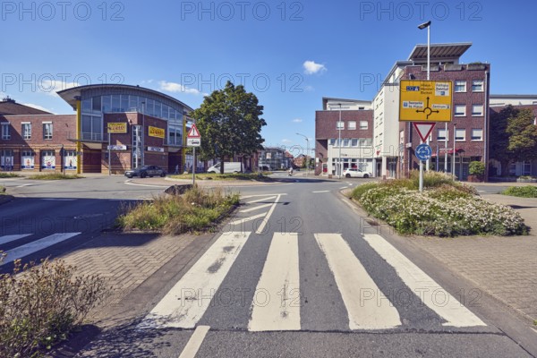 Pedestrian crossing, zebra crossing, central island, flower bed, general architecture, commercial building, modern architecture, street, lantern, signpost, trees, blue sky, cumulus clouds, roundabout between Butenwall, Bocholter Straße and Brinkstraße, Borken, Münsterland, Borken district, North Rhine-Westphalia, Germany