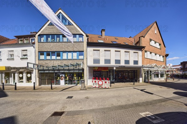 Optician hair house, residential and commercial building, modern architecture, general development, entrance, façade with windows and shop windows, dormers, gables, street made of concrete paving stones and paving stones, blue sky, cloudless, Heilig-Geist-Straße, Borken, Münsterland, Borken district, North Rhine-Westphalia, Germany