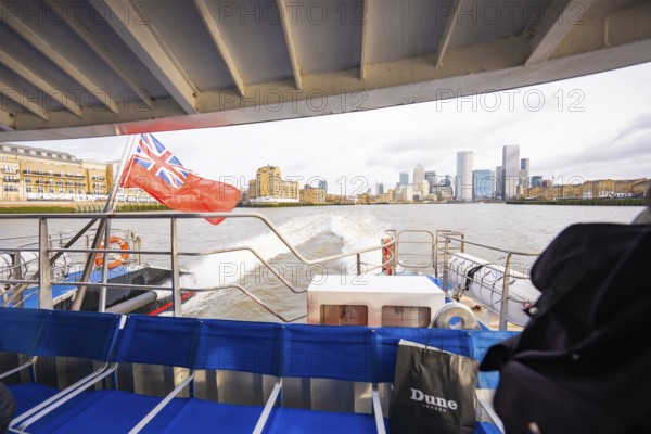 View of a city view from a boat with modern buildings and a flag, London, England, Great Britain