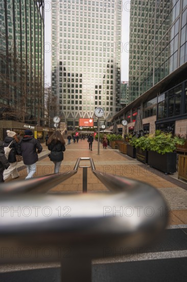 A busy walkway surrounded by tall modern skyscrapers and people walking, Canary Wharf, London, England, United Kingdom