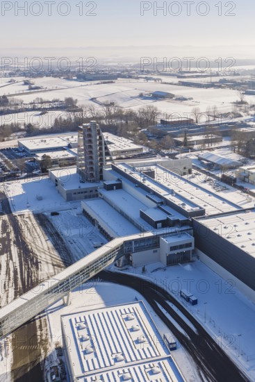Detailed aerial view of a snow-covered factory site with a distinctive tower, Häfele, Nagold, Germany