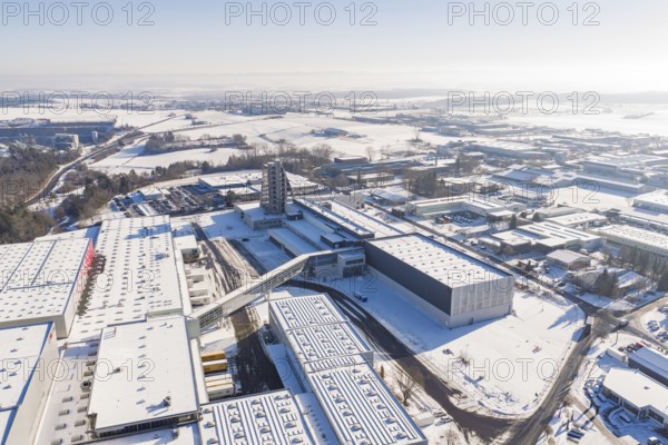 Long-range aerial view of a snow-covered industrial area with clear contours and blue sky, Häfele, Nagold, Germany