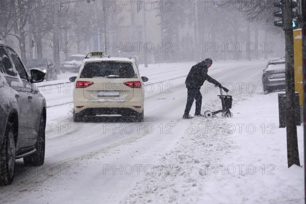 Senior with walker during heavy snowfall, winter, Germany