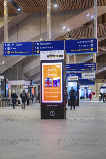 Lively train station with signs and people, modern decor and displays, London, England, Great Britain