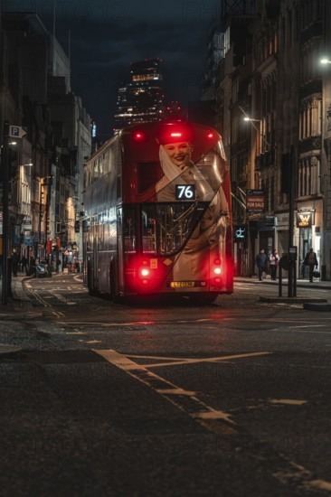 Double-decker bus travels at night through an illuminated city street surrounded by buildings, London, England, Great Britain