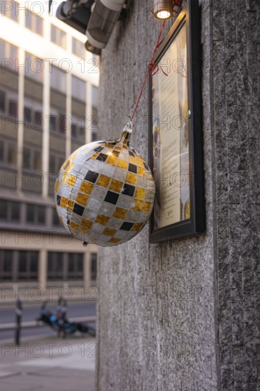 A decorative silver-gold ball hangs on a house wall, London, England, Great Britain