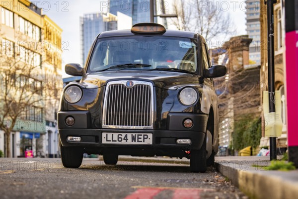 A black London taxi parked on a city street, London, England, Great Britain