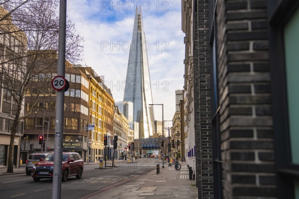 View of The Shard in London between city buildings under blue sky, London, England, Great Britain