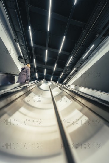 Modern escalator with long lights in a geometric interior, London, United Kingdom