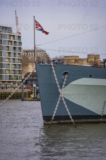 Front view of a ship in water with British flag surrounded by urban architecture, HMS Belfast, London, United Kingdom