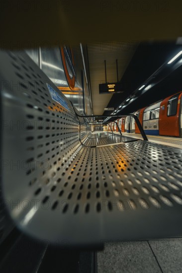 Seating area in a quiet subway station with a modern and metallic architecture, London, United Kingdom