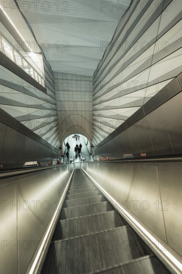 Modern escalator in futuristic architectural setting with people, London, United Kingdom
