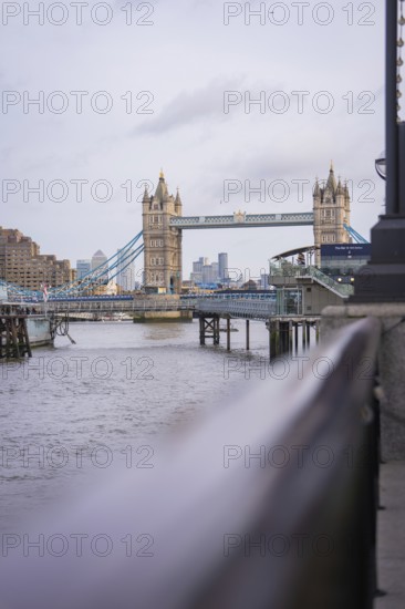 Historic bridge with towers over a river with an urban skyline in the background, Tower Bridge, London, United Kingdom