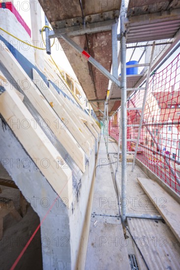 Scaffolding with protective net, view of timber structure and concrete, carpentry, renovation, roof extension, Stuttgart, Germany