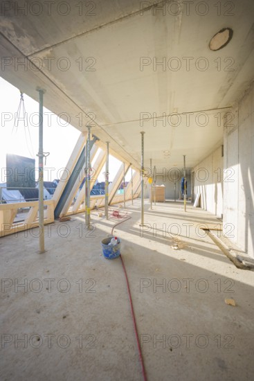 Light-flooded interior on a construction site with construction supports and woodwork, carpentry, renovation, roof extension, Stuttgart, Germany