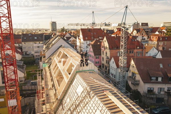 View of urban construction site in an old town with crane and roof work, carpentry, renovation, roof extension, Stuttgart, Germany