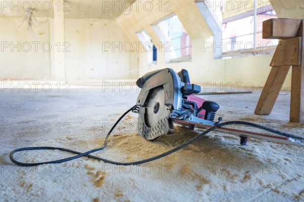 Interior of a construction site with a saw on the ground, carpentry, renovation, roof extension, Stuttgart, Germany