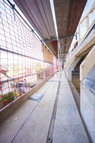 Long scaffolding with red nets, wooden elements and views of construction, carpentry, renovation, roof extension, Stuttgart, Germany