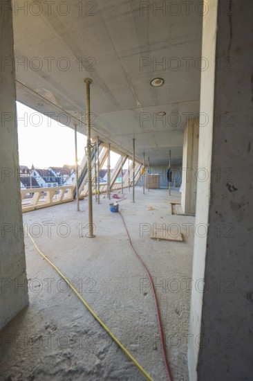 Open interior with construction work, exposed concrete walls and supports, carpentry construction site, roof extension, renovation, Stuttgart, Germany