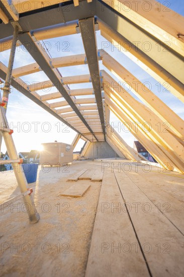 Light-flooded interior with wooden roof construction during construction, carpentry construction, roof extension, renovation, Stuttgart, Germany