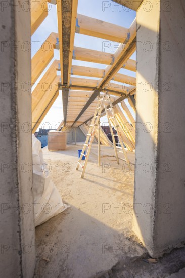 Interior construction site with wooden structure and ladder under incoming daylight, carpentry construction site, roof extension, renovation, Stuttgart, Germany