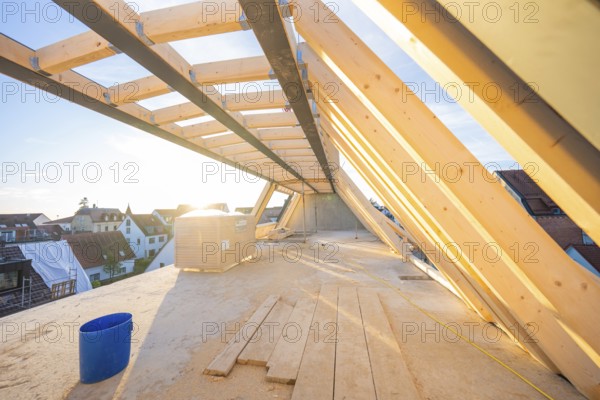Light-flooded roof truss in the construction process with a bucket on the ground, carpentry construction, roof extension, renovation, Stuttgart, Germany