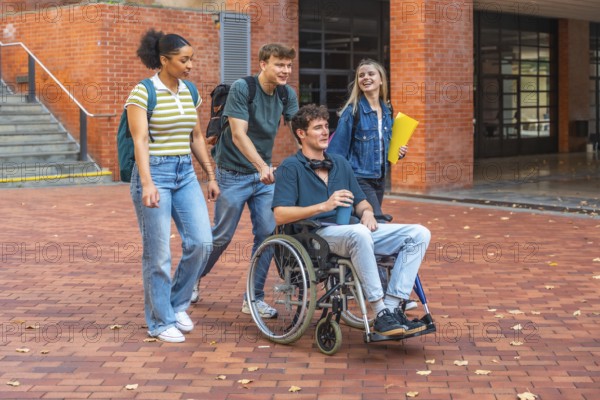 Young adult students walking and chatting on campus, diverse group including a male student in a wheelchair, showing inclusion, friendship and accessible university life