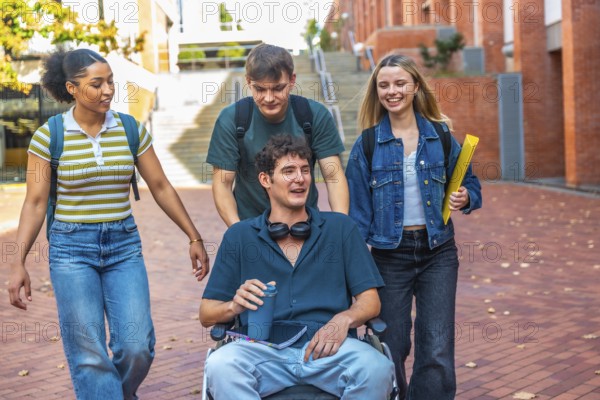 Group of diverse university students walking together on campus, one male student using a wheelchair being pushed by a friend, all engaging in conversation and smiling