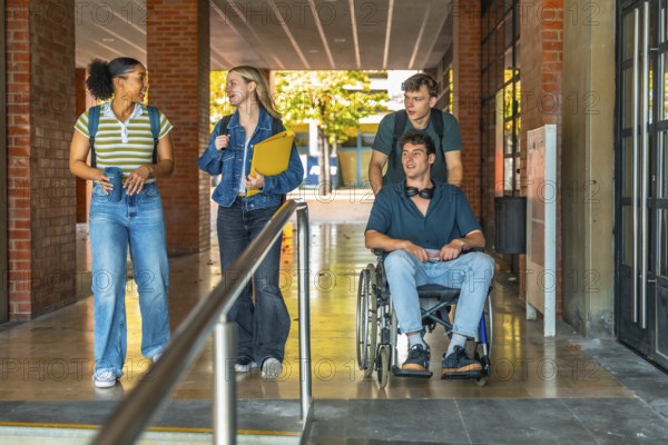 Group of young students, including one young man using a wheelchair, navigating an accessible university campus building, showing friendship, inclusion, and a diverse learning environment