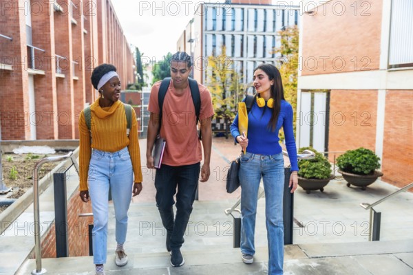Diverse students walking down university campus stairs during a sunny day, carrying backpacks and books, engaging in conversation, representing education, friendship, and youth